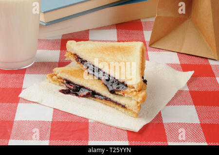 Ein Lunchpaket mit Erdnussbutter und Marmelade Sandwich mit einem Glas Milch Stockfoto