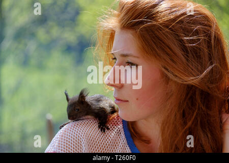 Portrait von rothaarigen Mädchen im Teenageralter mit Eichhörnchen auf der Schulter Stockfoto