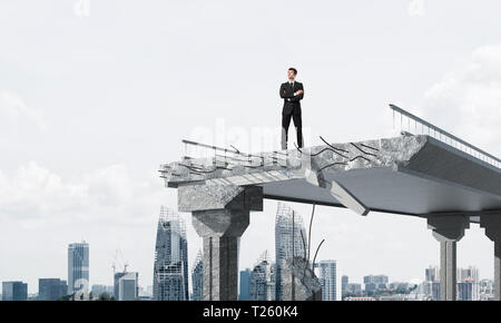 Zuversichtlich Geschäftsmann in Anzug weg schauen beim Stehen auf Broken Bridge mit Stadtbild auf Hintergrund. 3D-Rendering. Stockfoto