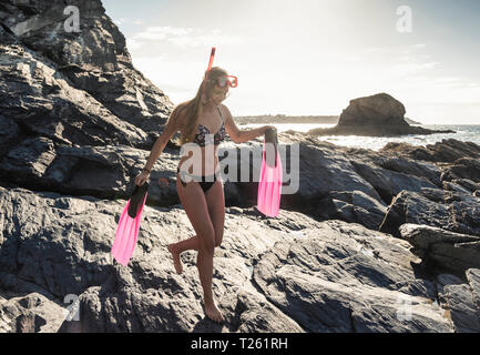 Glückliche junge Frau mit Schnorcheln am Strand Stockfoto