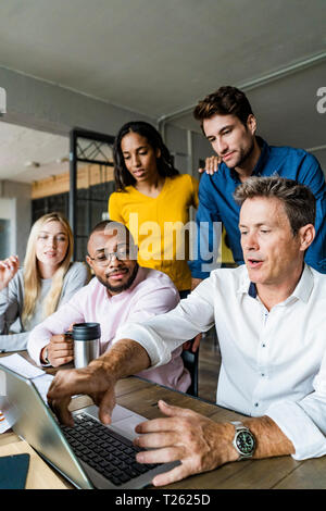 Business Team in einer Sitzung im Loft Büro auf Laptop zusammen Stockfoto