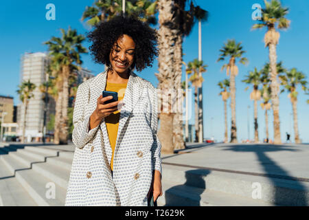 Beauutiful Frau in die Stadt pendeln, mit Smartphone Stockfoto