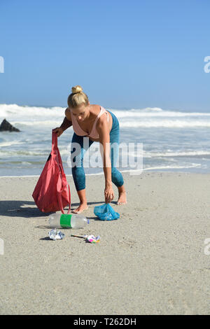 Schwangere Frau Reinigung der Strand von Kunststoffabfällen Stockfoto