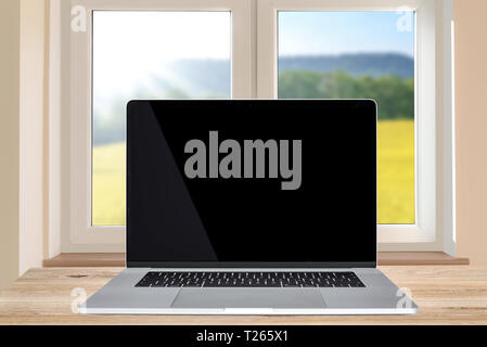 Das häusliche Leben Vorlage - generische modernen Laptop mit einem schwarzen Bildschirm auf einem hölzernen Tisch im Zimmer neben dem Fenster (gemischt). Stockfoto