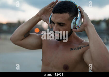 Portrait von barechested muskulösen Mann mit Kopfhörer im Freien Stockfoto