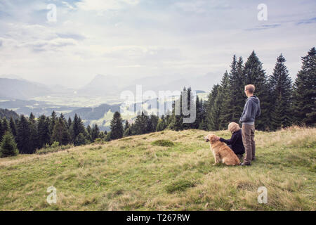 Österreich, Tirol, Kaisergebirge, Mutter und erwachsener Sohn mit Hund auf eine Wanderung in den Bergen Stockfoto