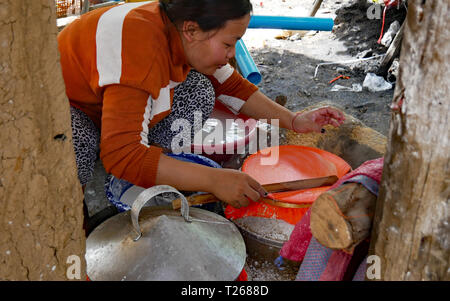 In Battambang, Kambodscha. Eine Frau nimmt vorsichtig nach einem nassen und zarte Blatt reispapier von der Oberfläche von der Dampfeinheit. 10-12-2018 Stockfoto