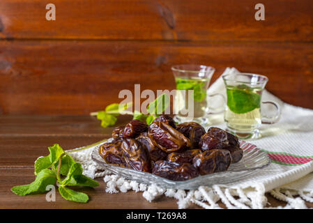 Iftar oder suhoor Snack in der Nähe der Termine auf Glasplatte mit mentha Tee auf Hintergrund, Ramadan Konzept Stockfoto