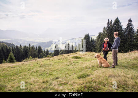 Österreich, Tirol, Kaisergebirge, Mutter und erwachsener Sohn mit Hund auf eine Wanderung in den Bergen Stockfoto