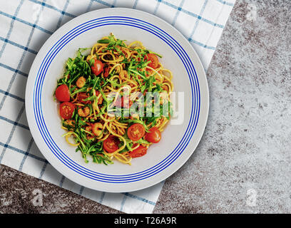 Pasta Teller mit Spaghetti mit Garnelen, Rucola und getrockneten und frischen Tomaten Stockfoto