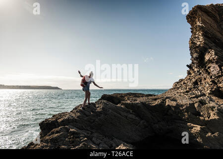 Junge Frau wandern auf einem felsigen Strand Stockfoto