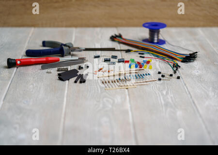 Leds, Widerstände und elektronische Komponenten mit Tools auf einem weißen vintage Hintergrund Stockfoto