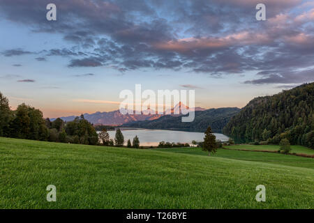 Blick auf den Weißensee bei Füssen Bayern mit Alpenglühen auf die Berge im Hintergrund Stockfoto