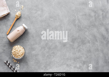 Hafermilch alternative auf grauem Hintergrund, Kopieren, Ansicht von oben. Gesund vegan Ersatz ohne Milchprodukte Getränk - Flasche hafermilch. Stockfoto