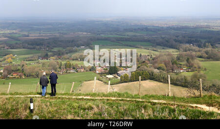 Die Menschen halten an, um die Ansicht zu schauen, wie Sie das warme Wetter in Ditchling Beacon auf der South Downs in Sussex genießen. Stockfoto