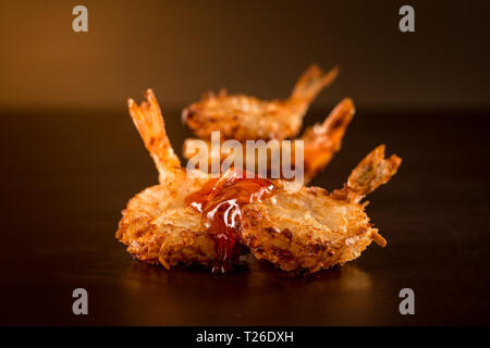 Gebratene Garnelen mit Sauce in einem Dark Ambient Stockfoto