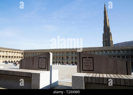 Sitzbank/Sitze mit Logo im Piece Hall mit quadratischen Kapelle Kirchturm im Hintergrund. Sonnig / Sonne und blauen Himmel. Halifax, West Yorkshire, UK. (106) Stockfoto