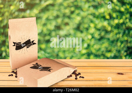 Bio Kaffee Mock-up in einer braunen Papiertüte auf einem rustikalen Holztisch. Natur Hintergrund und Tapeten. Einfach anzupassen. Stockfoto