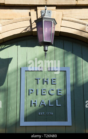 Tor in der Westwand, Eingang von Westgate, in das Stück Halle. Piece Hall Logo angezeigt wird. Sonnig / Sonne und blauen Himmel. Halifax, West Yorkshire, UK Stockfoto