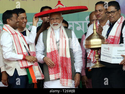 Assam. 30 Mär, 2019. Indische Ministerpräsident Narendra Modi (C), (vorne) ist Felicitated mit einem traditionellen Cap im Wahlkampf öffentlichen Sitzung im Nordosten Indiens Bundesstaat Assam am 30. März 2019. Credit: Stringer/Xinhua/Alamy leben Nachrichten Stockfoto