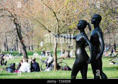 Leipzig, Deutschland. 30 Mär, 2019. Leipziger und Gäste der Stadt auf einer Wiese in der Clara Zetkin Park mit einem Bronze Skulptur im Vordergrund entspannen. Credit: Sebastian Willnow/dpa-Zentralbild/dpa/Alamy leben Nachrichten Stockfoto