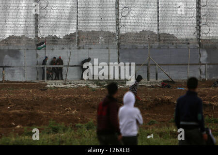 In Gaza. 30 Mär, 2019. Palästinensische Demonstranten Zusammentreffen mit israelischen Truppen auf der Gaza-Israel Grenze, östlich von Gaza-stadt, 30. März 2019. Tausende von Palästinensern am Samstag die palästinensische Land Tag und dem ersten Jahrestag der Palästinensischen große März zurück. Credit: Stringer/Xinhua/Alamy leben Nachrichten Stockfoto