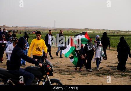 Gaza, Palästina. Am 30. März 2019. Palästinensische Frauen mit Flags im März gesehen. Palästinensische Demonstranten März gegenüber der Israel-Gaza Grenze, am ersten Jahrestag der großen Demonstration des Zurück Proteste. Credit: SOPA Images Limited/Alamy leben Nachrichten Stockfoto