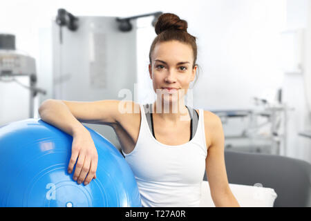 Beauty Fitness Trainer mit einem blauen Gymnastikball nach dem Training. Stockfoto