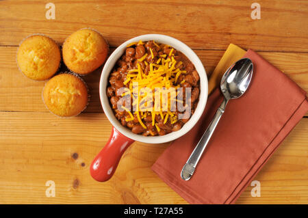 Eine Schüssel mit Chili und cornbread aus einem hohen Winkel Ansicht auf einem rustikalen Holztisch Stockfoto