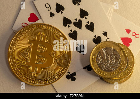 Nahaufnahme von Bitcoins zur Festlegung auf Poker Tisch mit Bündel von Münzen und Karten in den Hintergrund. Spielende on-line-Konzepte. Stockfoto