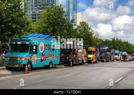 Mehrere bunte Essen alle Fahrzeuge sind in einer Reihe auf einer Straße neben einem öffentlichen Park an einem Samstag am 6. Oktober 2018 in Dallas, TX geparkt. Stockfoto