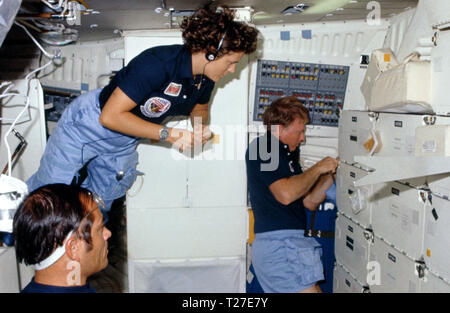 41 G -102-003 (5-13 Okt 1984) - - - - Astronaut Kathryn D. Sullivan, 41-G-Mission Specialist, schwimmt in einem middeck Szene ein Mehr stationäre Paar Crewmitglieder - - - Astronauten Robert L. Crippen, crew Commander zu verbinden; und Jon A. McBride, Pilot. Der vorstehende Artikel in der Nähe der Stauraum ist ein Krimsky Regel, Teil der in der Nähe von sehschärfe Experiment, in dem die Jüngsten NASA Space Travelers teilgenommen haben. Stockfoto