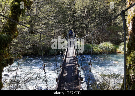 Wanderer auf die Drehbrücke über hoffnungslos Creek, Nelson Lakes National Park, Neuseeland. Stockfoto