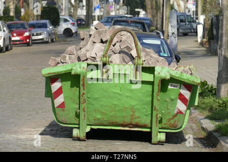 Alten grünen Sedimentation Mulde mit Bauschutt in einer Straße mit Wohnhäusern gefüllt, Deutscland, Europa Stockfoto