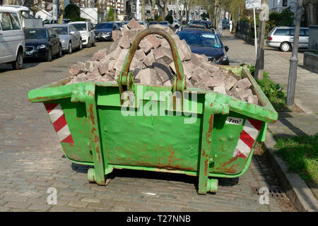 Alten grünen Sedimentation Mulde mit Bauschutt in einer Straße mit Wohnhäusern gefüllt, Deutscland, Europa Stockfoto