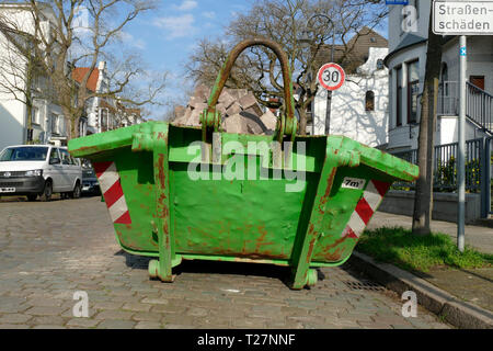 Alten grünen Sedimentation Mulde mit Bauschutt in einer Straße mit Wohnhäusern gefüllt, Deutscland, Europa Stockfoto