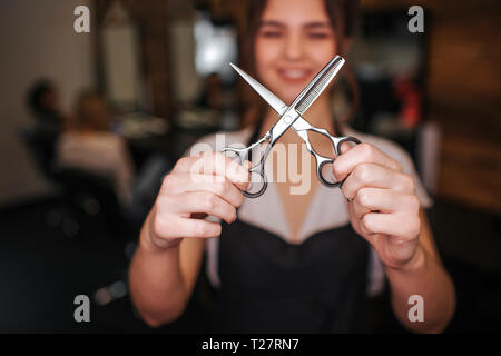 Close-up professionelle Metall Friseursalons Friseure schneiden Schere in der Hand. Friseursalons Werkzeug