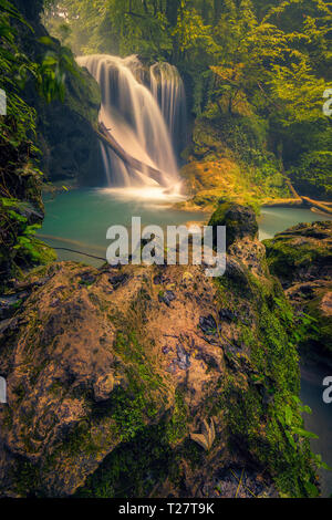 Schönen Wasserfall fließen auf ein Holz- und ein feuchtes Rock im Vordergrund Schuß in Rumänien Stockfoto