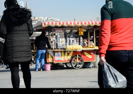 Istanbul, Türkei, März 07,2019: traditionelle Straße Warenkorb vending Verkauf von gekochtem und gegrilltem Mais außerhalb der Ägyptischen Basar, mit Passanten Stockfoto