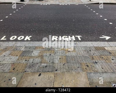 Suchen Sie passende Warnung gemalt auf einem Fußgängerüberweg in London, England, UK Stockfoto