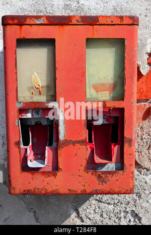 Alte vernachlässigt gumball Machine auf einem heruntergekommenen Haus Wand Stockfoto