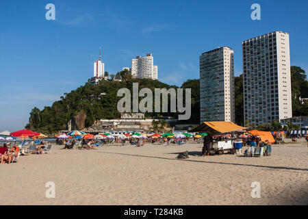 Die Menschen genießen einen öffentlichen Strand an einem warmen, sonnigen Tag entlang der Küste von São Vicente, am 8. Juli in Sao Vicente, Brasilien 2018. Stockfoto