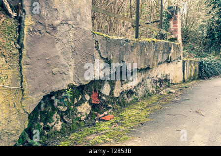 Alten, verfallenen Friedhof an der Wand. Von Steinen und Ziegeln. Bayern, Deutschland. Stockfoto