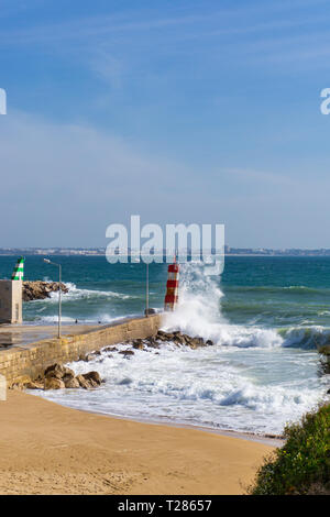 Wave Spritzer gegen Leuchtturm in Lagos, Portugal Stockfoto