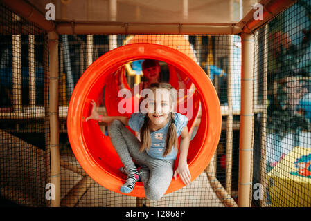 Zwei kleine Mädchen klettern das Labyrinth bei Kindern Game Center. Aufgeregt childs Spaß auf dem Spielplatz im Freien. Kinder spielen in Amusement Center Stockfoto