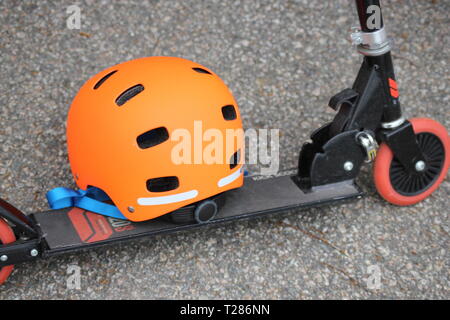 Kinder kick Board und eine orange Helm. Verkehrssicherheit. Kinder mit aktivem Lebensstil. Stockfoto