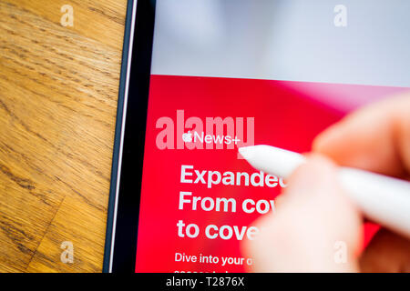 Paris, Frankreich - Mar 27, 2019: Apple News Plus Demo Website auf dem iPad pro Mann zeigt mit Apple Bleistift auf dem Bildschirm Stockfoto