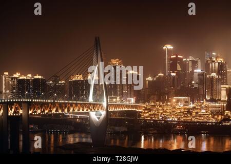 Qiansimen Brücke mit Hongyadong Shopping Complex und Stadt städtische Architektur bei Nacht in Chongqing, China. Stockfoto