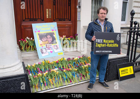 Richard Ratcliffe, der Ehemann der Britischen liebe Nazanin Zaghari-Ratcliffe Arbeiter, die in Iran abgehalten wird, wo sie der Spionage beschuldigt wird, mit einem riesigen MotherÕs Tag Karte und Blumen auf den Stufen der iranischen Botschaft in Knightsbridge, London, als er zur Kampagne für die Freigabe seiner Frau fort. Stockfoto