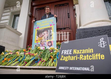 Richard Ratcliffe, der Ehemann des britischen Wohltätigkeitsarbeiters Nazanin Zaghari-Ratcliffe, Der im Iran festgehalten wird, wo sie mit einer riesigen Muttertagskarte und Blumenstrauß auf den Stufen der iranischen Botschaft in Knightsbridge, London, der Freilassung seiner Frau vorgeworfen wird. Stockfoto